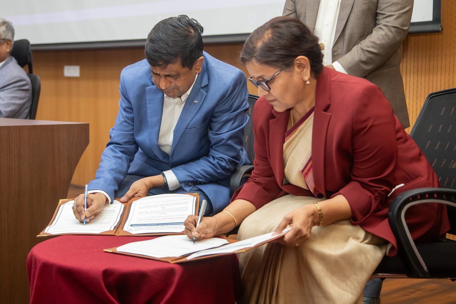 The Member Secretary of MPSLSA and the Vice-Chancellor of DNLU signing the Memorandum of Understanding